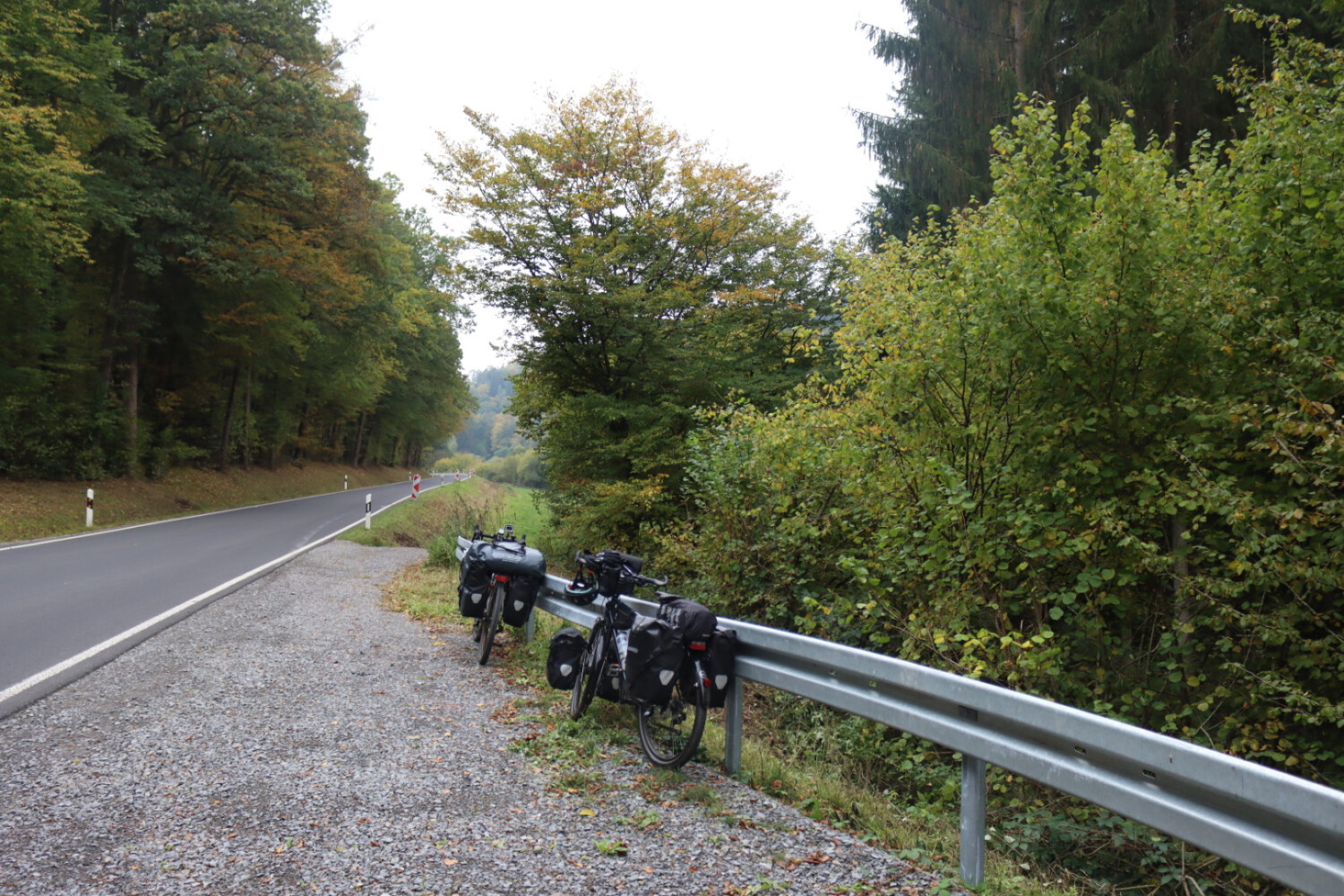 Bikes lean against guardrails at a street in Odenwald