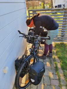 A woman packing stuff to her bicycle.