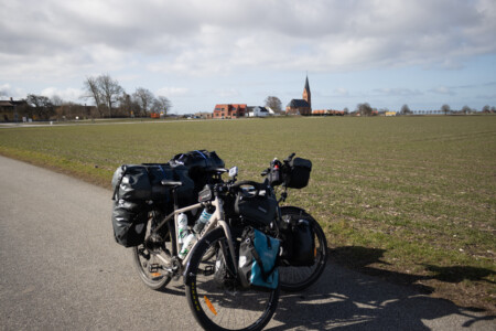 Two bikes in front of a church from a small town in the south of sweden.